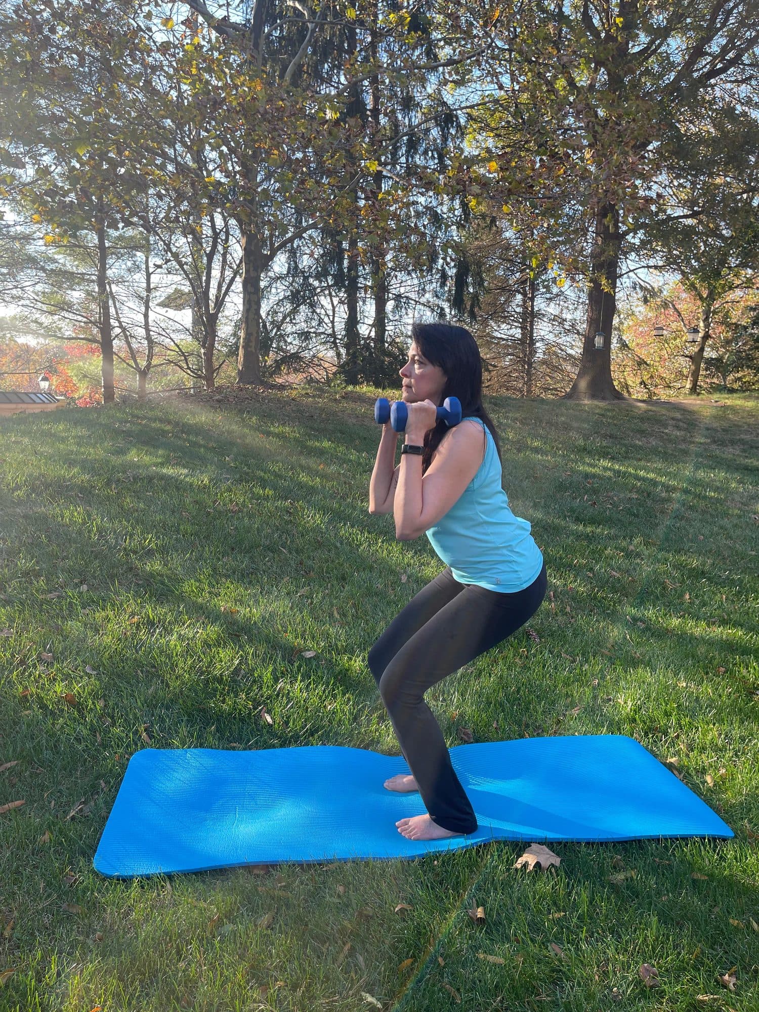 Misha doing a weighted squat outdoors